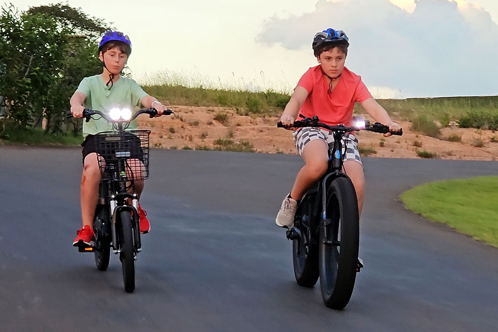 Two kids on e-bikes