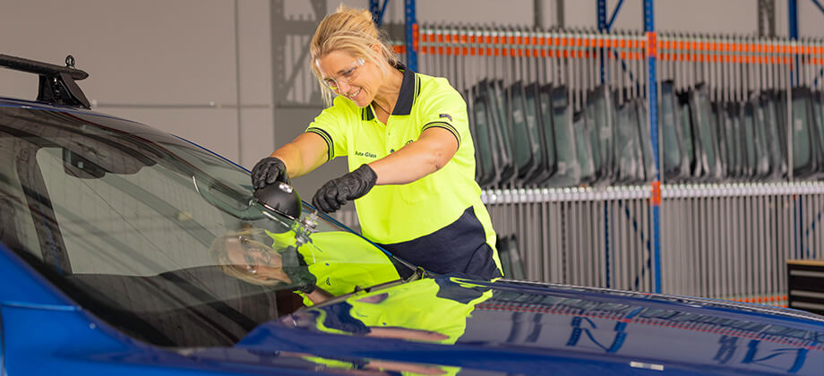 Female auto glass technician fixing windscreen chip