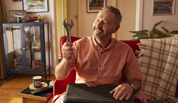 man with toolbox sitting on couch repco