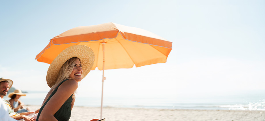 lady at the beach under carousel umbrella